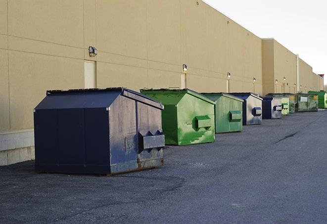 a construction worker moves construction materials near a dumpster in Ellabell GA